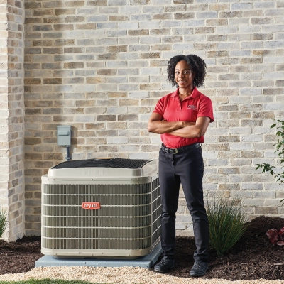 female bryant tech standing next to unit